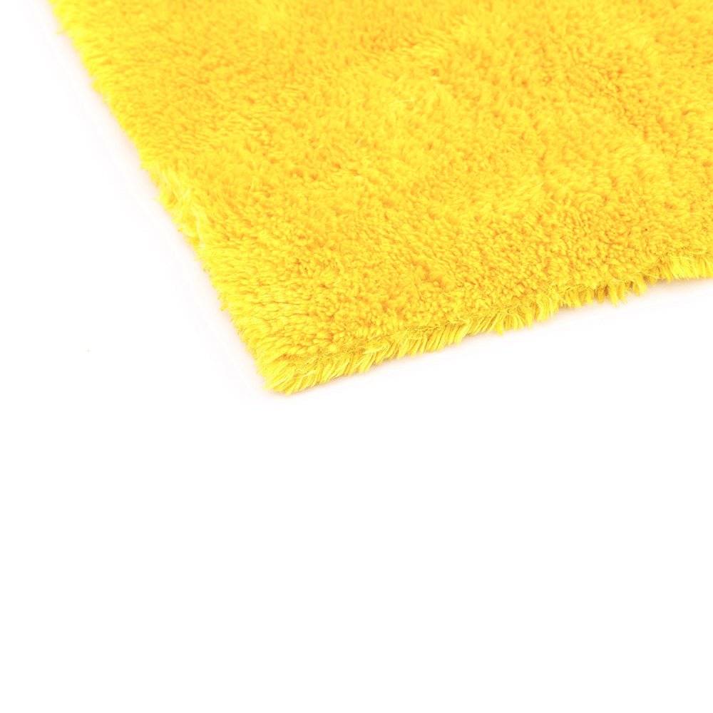 The corner of a yellow 16x16 Eagle Edgeless Towel from The Rag Company. Having no edges or tags prevents scratching paint or glass.